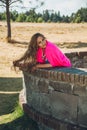 Mature woman enjoys a sunny day in a park with traditional Mexican overflow of pink color