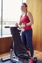 Mature Woman Exercising In Home Gym Taking A Break And Drinking Water