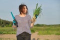 Mature woman farmer walking through the garden with green fresh chive onion Royalty Free Stock Photo