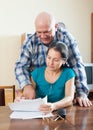 Mature woman fills documents, man helps her Royalty Free Stock Photo