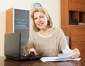 Mature woman fills in the questionnaire in laptop