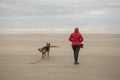 Mature woman with German Shepherd dog at the beach Royalty Free Stock Photo