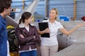 Mature woman giving tour aircraft hangar