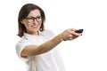 Mature woman with glasses and light shirt holding remote control in hand. White background isolated