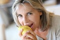 Mature woman with grey hair eating a pear Royalty Free Stock Photo