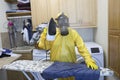 Mature woman in Haz Mat suit ironing shirt on board Royalty Free Stock Photo