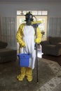 Mature woman in Haz Mat suit with mop and bucket