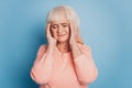 Mature woman with headache holding her temples feel unwell on blue backdrop Royalty Free Stock Photo