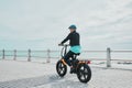Mature woman, helmet or electrical bike by beach for future fitness, clean energy transport or sustainability travel