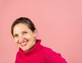 A mature woman in her early fifties with a pink turtleneck smiling at the camera with room for copy Royalty Free Stock Photo