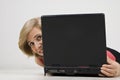 Mature woman hide behind laptop