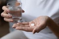 Mature woman holding glass of water and taking painkiller Royalty Free Stock Photo