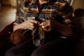 Mature woman in home clothes sitting on sofa in living room and knitting with needles and ball of thread closeup Royalty Free Stock Photo