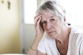 Mature woman at home touching her head with her hands while having a headache pain Royalty Free Stock Photo