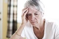 Mature woman at home touching her head with her hands while having a headache pain Royalty Free Stock Photo