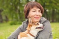 Mature woman hugging corgi puppy dog  outdoors Royalty Free Stock Photo