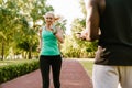 Mature woman jogging together with african trainer outdoors in park Royalty Free Stock Photo