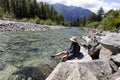 Mature woman kicking her feet into the cool river water during a summer time Royalty Free Stock Photo