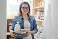 Woman in kitchen pantry. Storage wooden stand with kitchenware, products necessary to cook Royalty Free Stock Photo