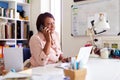 Mature Woman With Laptop Working In Home Office Using Mobile Phone Royalty Free Stock Photo