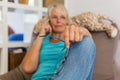 Mature woman lies on a seating furniture while she takes a phone call