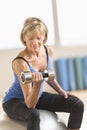 Mature Woman Lifting Dumbbell On Fitness Ball