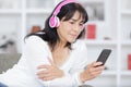 mature woman listening to audio and carrying phone