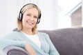 Mature Woman Listening To Music On Wireless Headphones