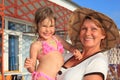 Mature woman with little girl on hands outdoor