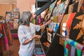 Mature woman looking at colorful fabric in her shop Royalty Free Stock Photo