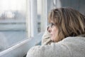 Mature woman looking out the window on a rainy day Royalty Free Stock Photo