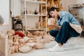 Woman looking at pottery handcrafts while sitting at the workshop Royalty Free Stock Photo