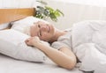 Mature woman lying down in her bed at home Royalty Free Stock Photo