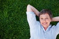 Mature woman lying on grass. Top view of mature woman smiling while lying on grass. Royalty Free Stock Photo