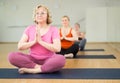 Senior woman meditating at group yoga class Royalty Free Stock Photo