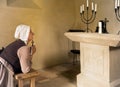 Woman praying in medieval chapel