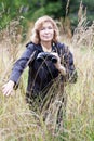 Mature woman a naturalist studying birds in their natural surroundings, female is in high dry grass, portrait