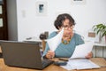 Mature woman paying bills with laptop at home Royalty Free Stock Photo