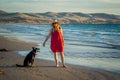 Mature woman and pet dog walking together on empty beach in the new normal after coronavirus Royalty Free Stock Photo