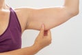 Mature woman pinching flabby arm body care and fitness concept