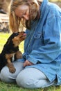 Mature woman playing with affectionate cute pup Royalty Free Stock Photo