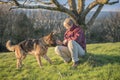 Mature woman playing with her pet Alsatian dog Royalty Free Stock Photo