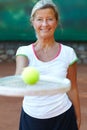 Mature, woman and portrait smile for tennis racket on court or ball play, retirement workout or match ready. Female Royalty Free Stock Photo