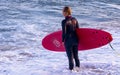 Mature woman posing with a surfboard on the beach