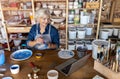 Mature woman pottery artist using laptop in art studio