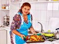 Mature woman preparing chicken at kitchen