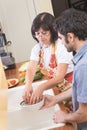 Mature Woman Preparing Vegetables in Kitchen with Son