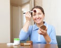 Mature woman puts facepowder on face Royalty Free Stock Photo