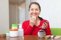 Mature woman putting facepowder on face