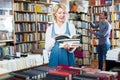 Mature woman reading book in book shop Royalty Free Stock Photo